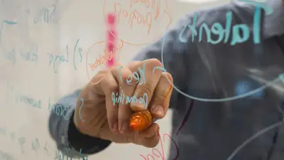 Persona escribiendo ideas y diagramas en una pizarra de cristal para validar una idea de negocio